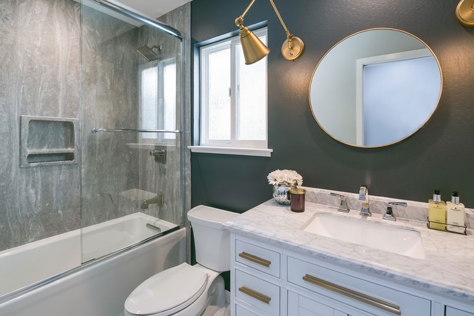 An easy to clean cultured granite grey pearl shower wall slab lines the shower walls.