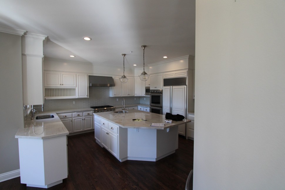 the blue-painted island off sets the white perimeter cabinetry beautifully